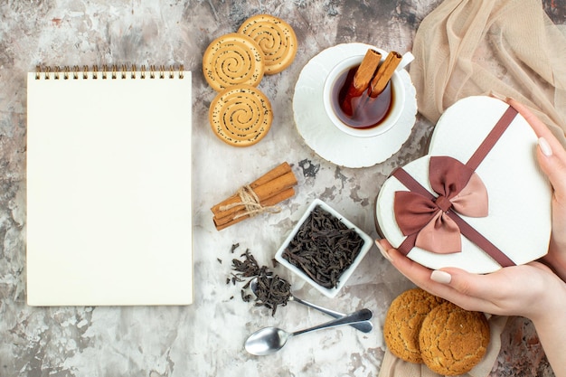 Draufsicht Tasse Tee mit süßen Keksen und Geschenk auf hellem Hintergrund Valentinstag Paar Gefühl Cookie Farbe Liebe Ehe