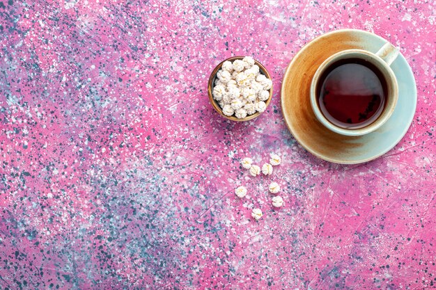 Draufsicht Tasse Tee mit weißen süßen Confitures auf der rosa Oberfläche