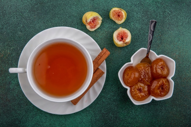 Draufsicht Tasse Tee mit Zimt und Feigenmarmelade auf grünem Hintergrund