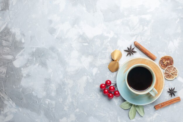 Draufsicht Tasse Tee mit Zimt und getrockneter Zitrone auf dem weißen Schreibtisch Tee Bonbon Farbe Frühstück