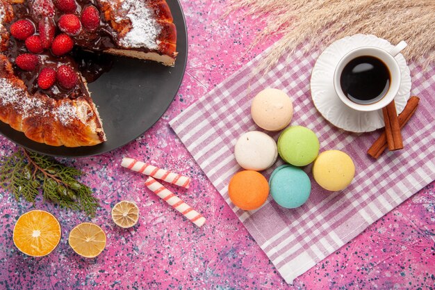 Draufsicht Tasse Tee mit Zimtkuchen und französischen Macarons auf rosa Schreibtischkuchen Kekskeks süßer Zucker