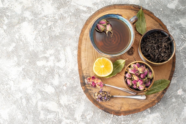 Draufsicht tasse tee mit zitrone und blumen auf hellem hintergrund frühstückszeremonie aroma fruchtlebensmittelfarbe morgenblume