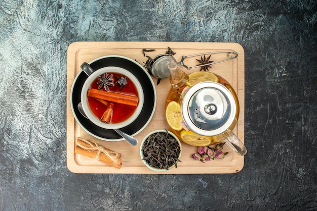 Draufsicht Tasse Tee mit Zitrone und Wasserkocher auf grauem Hintergrund Obstfrühstückszeremonie Farbfoto Essen Morgen