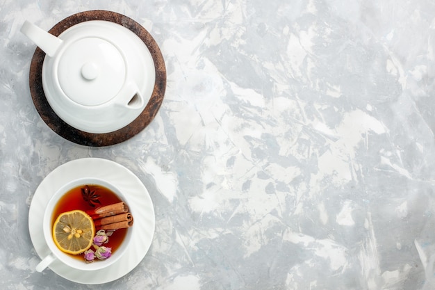 Draufsicht tasse tee mit zitrone und zimt auf der hellweißen oberfläche