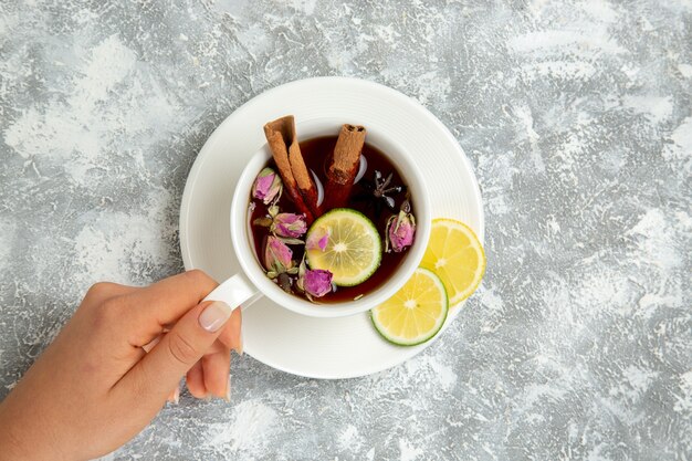 Draufsicht Tasse Tee mit Zitronenscheiben und Zimt auf weißem Hintergrund Tee trinken heißes süßes Zuckerfrühstück