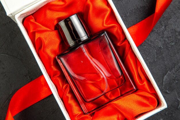 Draufsicht teures Parfüm in eleganter Verpackung als Geschenk auf dunklem Tisch