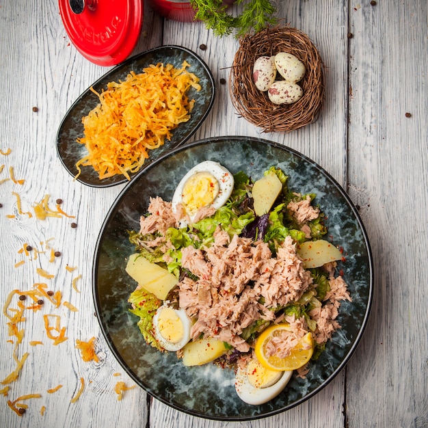 Draufsicht Thunfischsalat in Platte mit Eiern, Kartoffeln und Eiern auf Holztisch