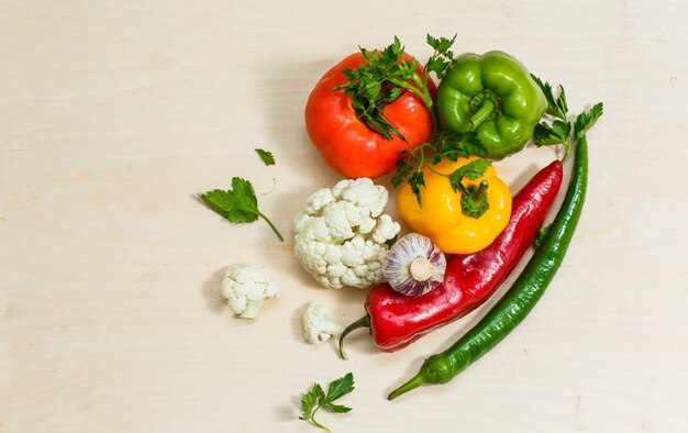 Draufsicht Tomate mit Paprika, Blumenkohl, Grün, Chilischoten auf Weiß. horizontal