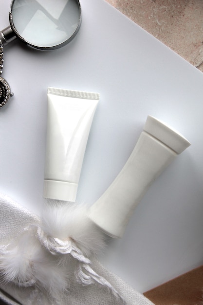 Draufsicht Tube Creme mit Lotion und Lupe