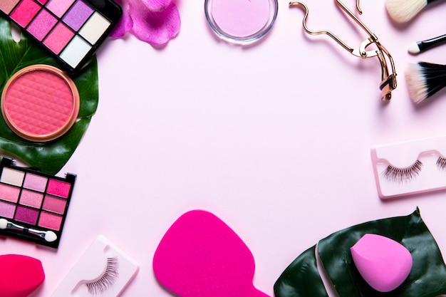 Draufsicht über Kosmetik auf rosa Hintergrund mit Kopienraum