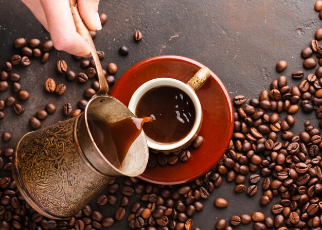 Draufsicht übergeben strömenden Kaffee in Schale