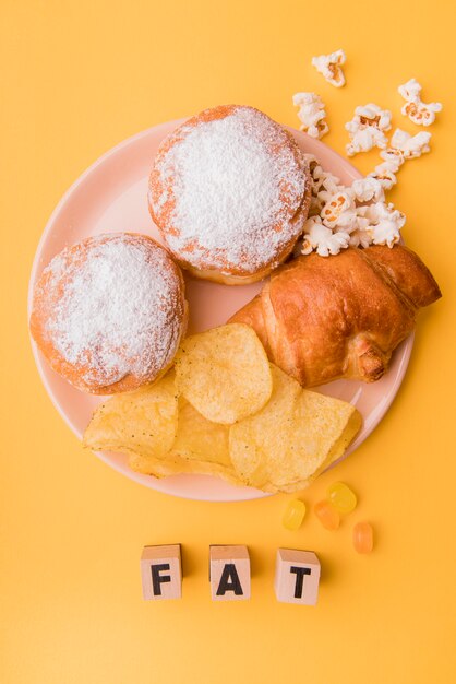 Draufsicht ungesunde Snacks mit fetten Buchstaben