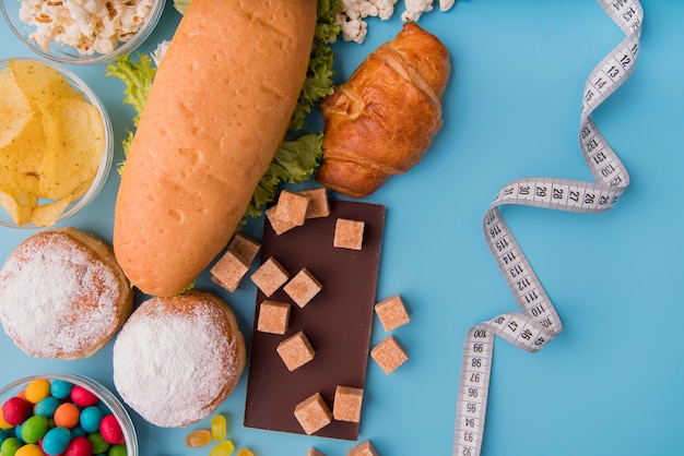 Kostenloses Foto draufsicht ungesundes essen und maßband