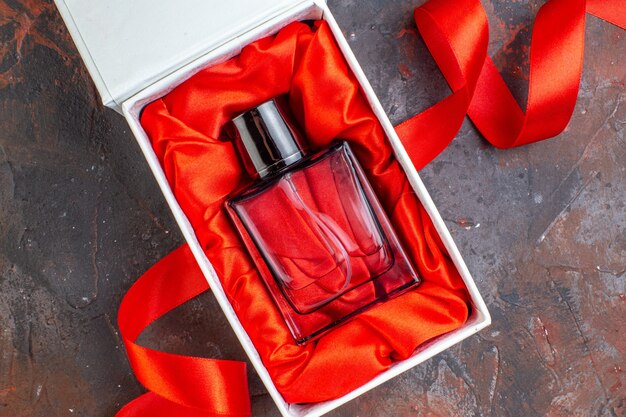 Draufsicht Valentinstag Geschenk Duft im Paket auf der dunklen Oberfläche Geschenk Parfüm Liebespaar Gefühl Farbe