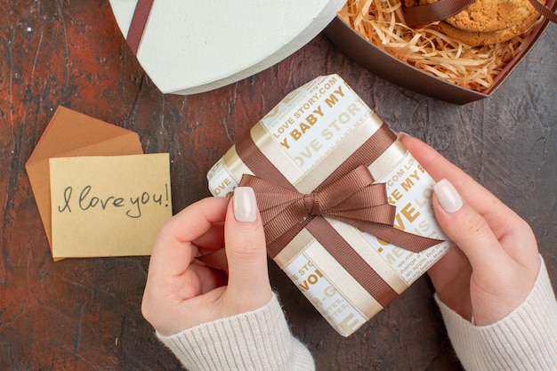 Draufsicht Valentinstag Geschenk mit Notiz und Keks auf dunklem Hintergrund Ehe Urlaub Gefühl Paar Geschenk Liebe