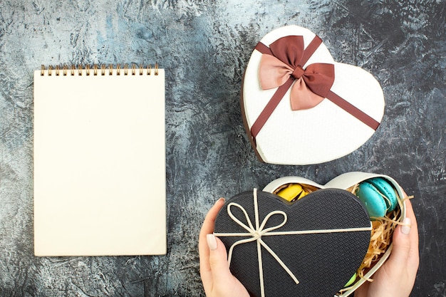 Draufsicht Valentinstag präsentieren französische Macarons im Paket auf grauem Hintergrund Gefühl Geschenk Keks Kuchen Paar Ehe glücklich
