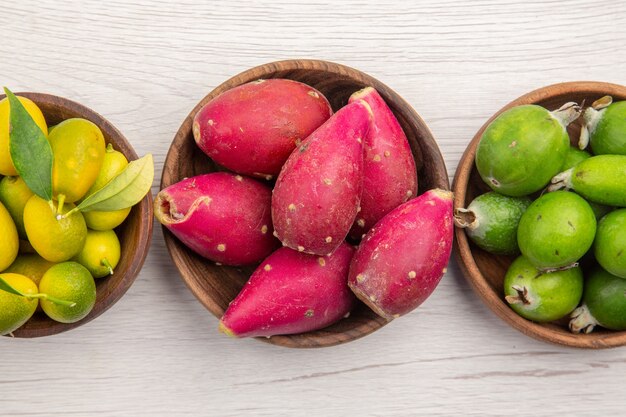 Draufsicht verschiedene frische Früchte in Platten auf weißem Hintergrund exotische tropische reife Ernährung Farbe gesundes Leben