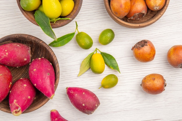 Draufsicht verschiedene frische Früchte in Platten auf weißem Hintergrund Obst tropische reife Ernährung exotische Farbe