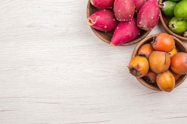 Draufsicht verschiedene frische Früchte in Platten auf weißem Hintergrund Obst tropische reife Ernährung exotisches gesundes Leben