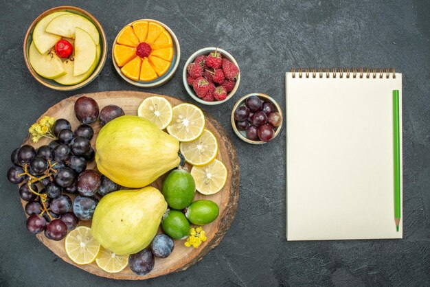 Draufsicht verschiedene Fruchtzusammensetzung frisch und reif auf dunkelgrauem Hintergrund ausgereifte Früchte Gesundheit reif frisch