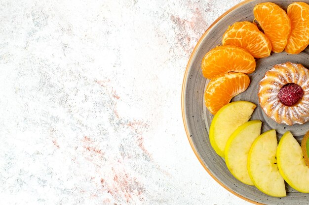 Draufsicht verschiedene früchte zusammensetzung frische und geschnittene früchte mit kuchen auf weißem schreibtisch reife früchte farbe gesundheit