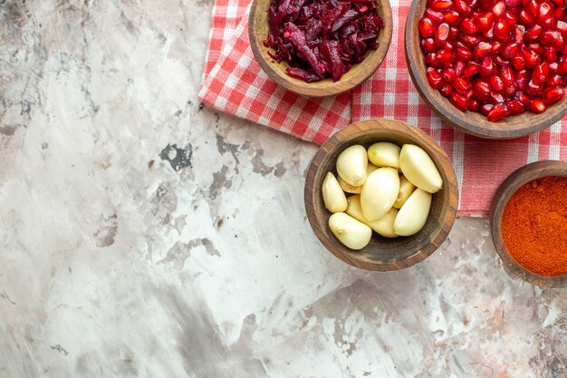 Draufsicht verschiedene Gewürze Knoblauch Granatäpfel und Rüben auf hellem Hintergrund