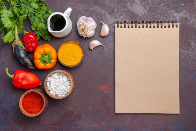 Draufsicht verschiedene Gewürze mit frischem Gemüse auf dem dunklen Hintergrund Salatgemüseprodukt Lebensmittelmahlzeit