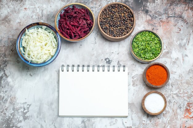 Kostenloses Foto draufsicht verschiedene gewürze mit geschnittenem kohl und rüben auf weißem hintergrund