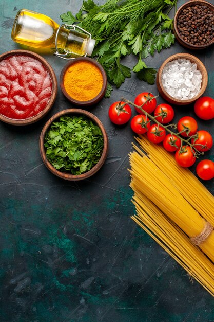 Draufsicht verschiedene Gewürze mit Olivenöl und frischen roten Tomaten auf Rohstoffprodukt der dunklen Schreibtischnahrungsmahlzeit