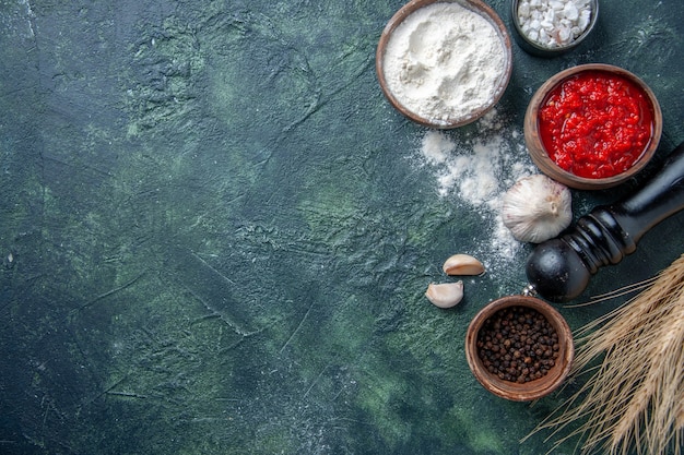 Draufsicht verschiedene Gewürze mit Tomatensauce und Mehl auf dunklem Hintergrund Tomaten reifen Salat Gemüse Farbe Teig Mahlzeit