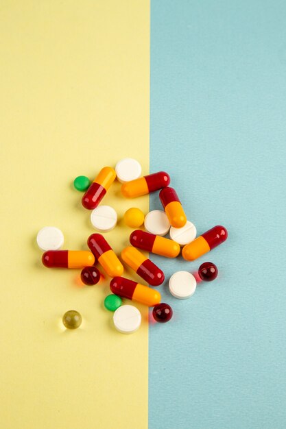 Draufsicht verschiedene Pillen auf gelbem blauem Hintergrund