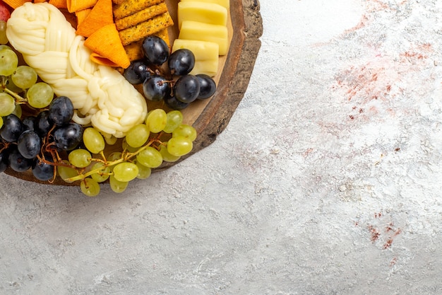 Kostenloses Foto draufsicht verschiedene snacks cips würstchen käse und frische trauben auf dem hellen weißen raum