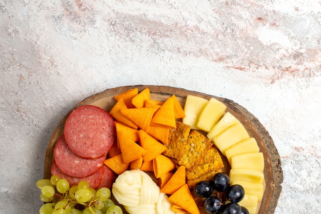 Draufsicht verschiedene Snacks cips Würstchen Käse und frische Trauben auf weißem Boden Essen Mahlzeit Snack Obstkäse