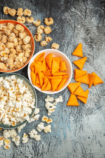 Draufsicht verschiedene Snacks für Filmzeit auf hell-dunkler Oberfläche