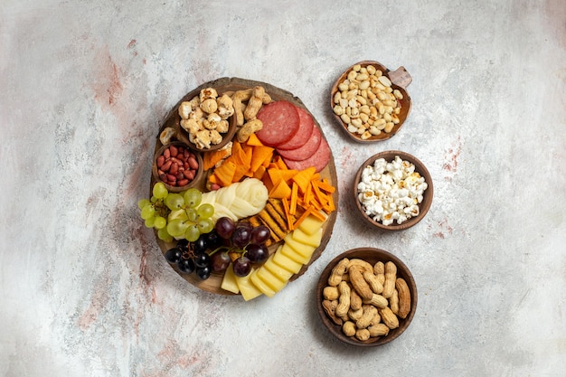 Draufsicht verschiedene Snacks Nüsse Cips Käse und Würstchen auf weißem Hintergrund Nuss Snack Mahlzeit Essen