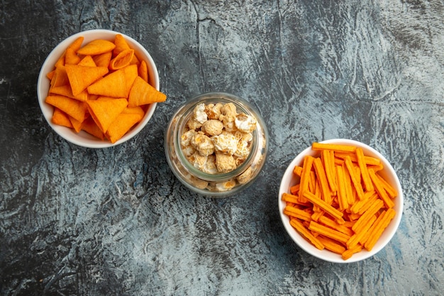 Draufsicht verschiedene Snacks Popcorn Zwieback und Cips auf der dunklen Oberfläche