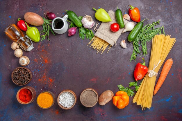 Draufsicht verschiedene Zutaten rohe Nudeln frisches Gemüse und Gewürze auf dunkler Oberfläche Produkt frische Mahlzeit Salat Gesundheitsdiät