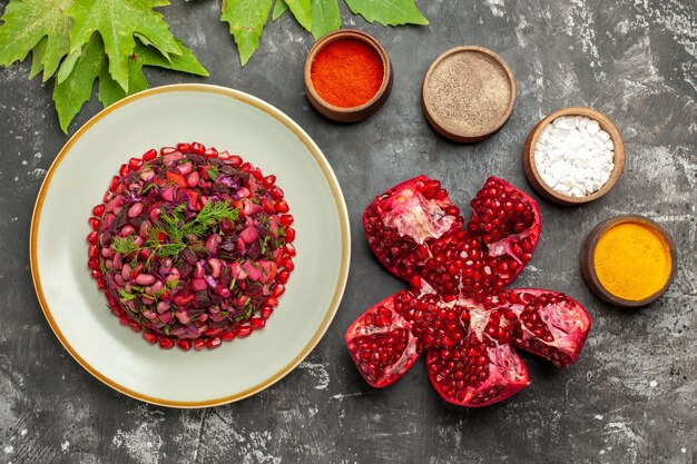 Draufsicht-Vinaigrette-Salat mit Gewürzen auf dunklem Schreibtisch