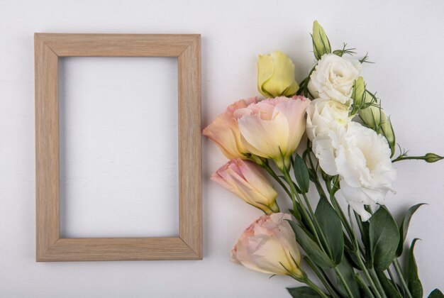 Draufsicht von Blumen und Rahmen auf weißem Hintergrund mit Kopienraum