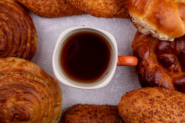 Draufsicht von Brötchen wie Sesamfrikadellen gogal mit einer Tasse Tee auf einem weißen Hintergrund