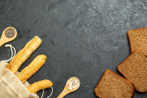 Draufsicht von Brötchenbrot mit dunklen Brotlaib auf grauer Oberfläche