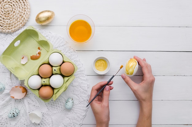 Draufsicht von den Händen, die Ei für Ostern färben