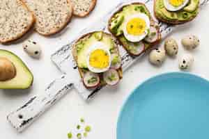 Kostenloses Foto draufsicht von ei und avocado-sandwiches auf tisch mit teller