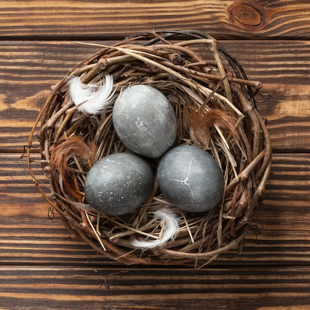 Draufsicht von Eiern für Ostern mit Federn im Vogelnest