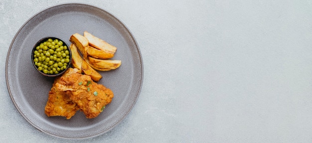 Draufsicht von Fish and Chips mit Erbsen auf Teller und Kopierraum