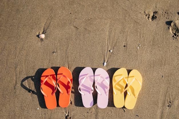 Kostenloses Foto draufsicht von flipflops am strand mit copyspace