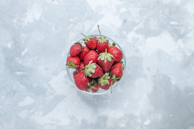 Draufsicht von frischen roten Erdbeeren milden Sommerbeeren innerhalb der Glasplatte auf hellem Schreibtisch, Beerenfrucht mildes Vitamin