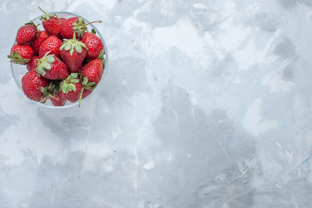 Draufsicht von frischen roten Erdbeeren milden Sommerbeeren innerhalb der Glasplatte auf hellem Schreibtisch, Beerenfrucht mildes Vitamin