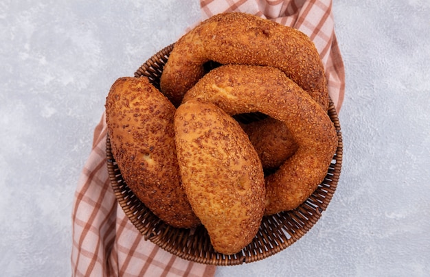 Draufsicht von frischen türkischen Bagels auf einem Eimer auf einem karierten Tuch auf einem weißen Hintergrund