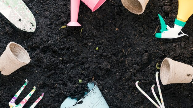 Draufsicht von Gartenarbeitausrüstungen vereinbarte auf schwarzem Boden